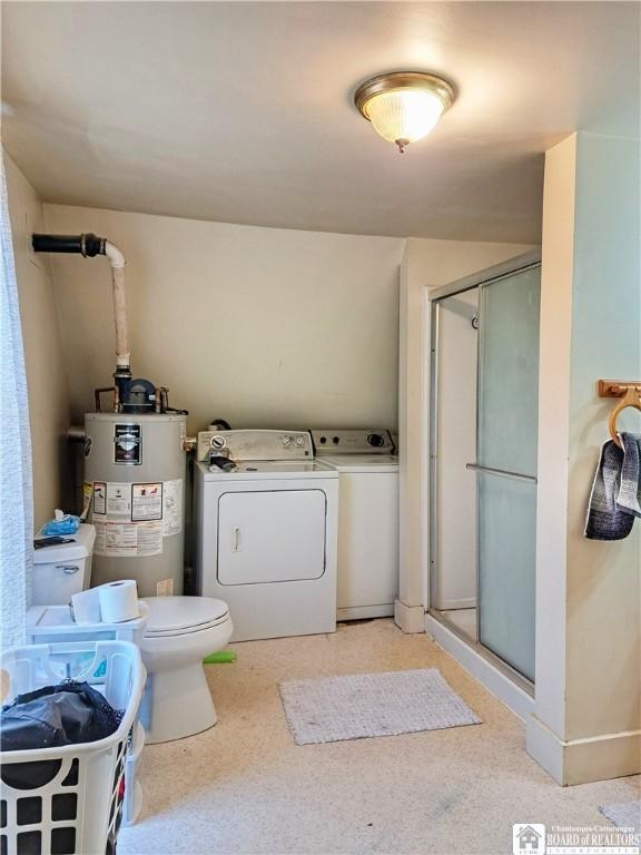 bathroom with toilet, a shower stall, water heater, and washer and dryer