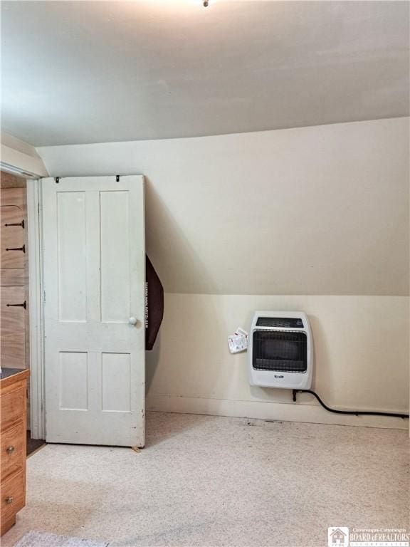 additional living space featuring heating unit, carpet, and lofted ceiling