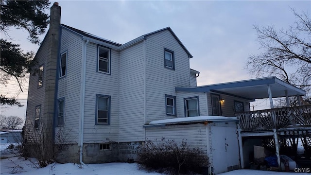 snow covered property featuring a chimney