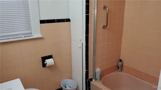 bathroom with bathtub / shower combination and tile walls