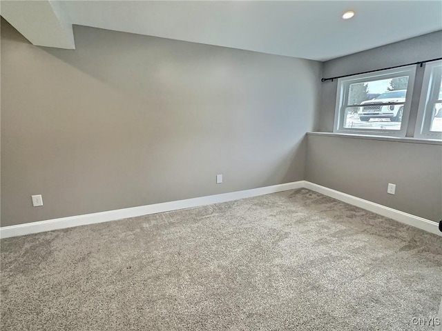 carpeted empty room with baseboards