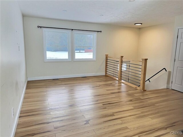 unfurnished room featuring light wood-type flooring and baseboards