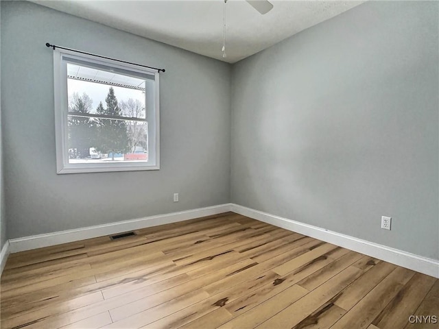 unfurnished room featuring visible vents, baseboards, ceiling fan, and wood finished floors