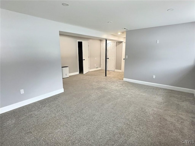 carpeted spare room with visible vents and baseboards