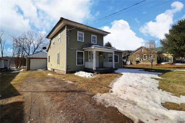 view of front of house featuring an outbuilding, covered porch, and dirt driveway