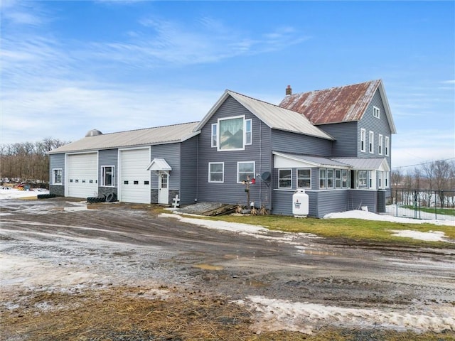 view of front of property featuring metal roof and a chimney