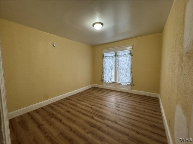 unfurnished room with wood finished floors and baseboards