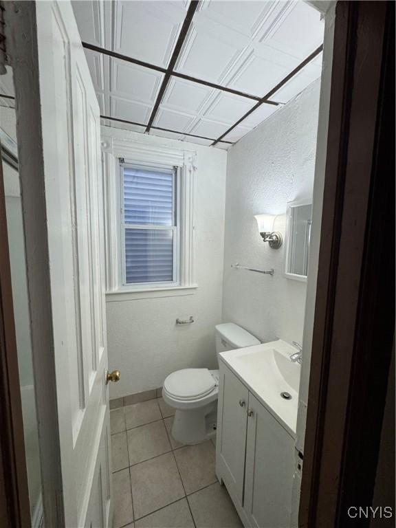 bathroom with toilet, tile patterned flooring, and vanity