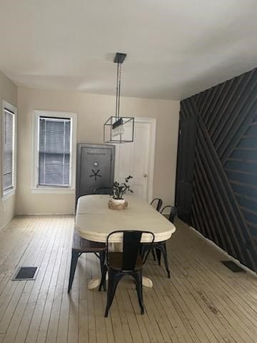 dining area featuring light wood-style floors and visible vents