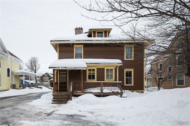 american foursquare style home with covered porch and a chimney