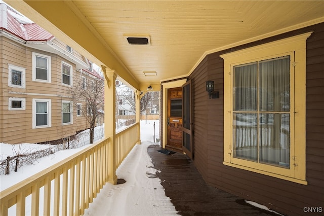 view of snow covered back of property