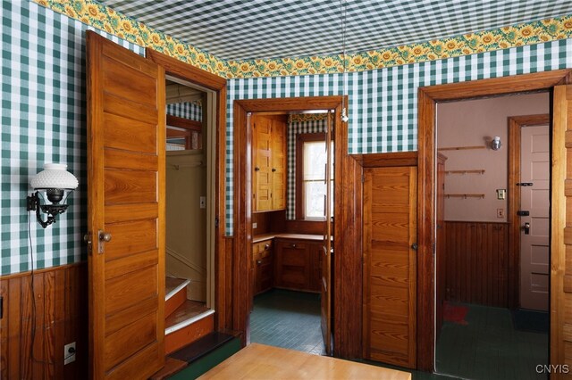 interior space featuring a wainscoted wall, light wood-style flooring, and wallpapered walls