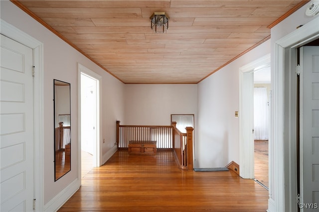 hall featuring wooden ceiling, wood finished floors, an upstairs landing, and crown molding