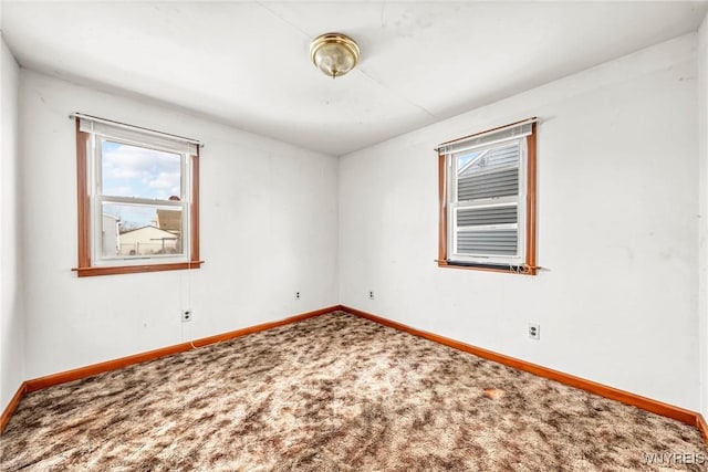 carpeted empty room featuring baseboards