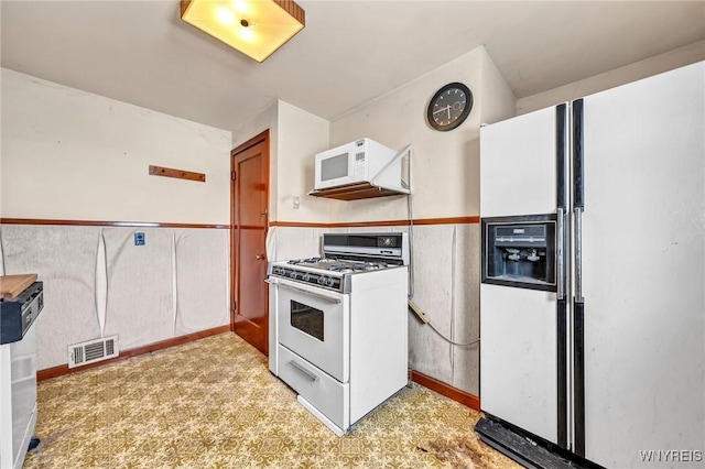 kitchen with white appliances and visible vents