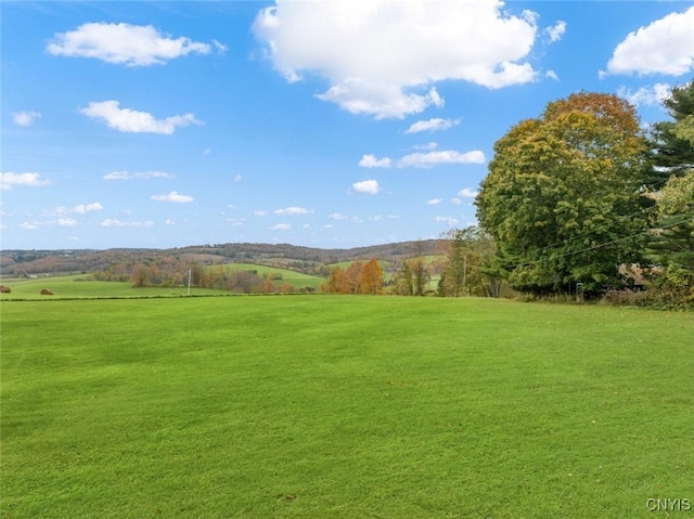 view of home's community featuring a rural view and a lawn