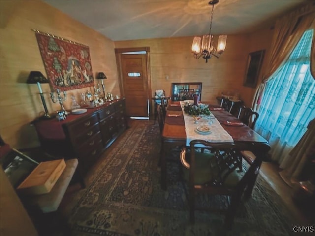 dining area featuring wood finished floors and a notable chandelier