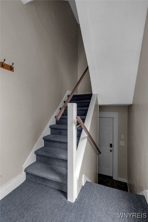 stairway featuring carpet and baseboards