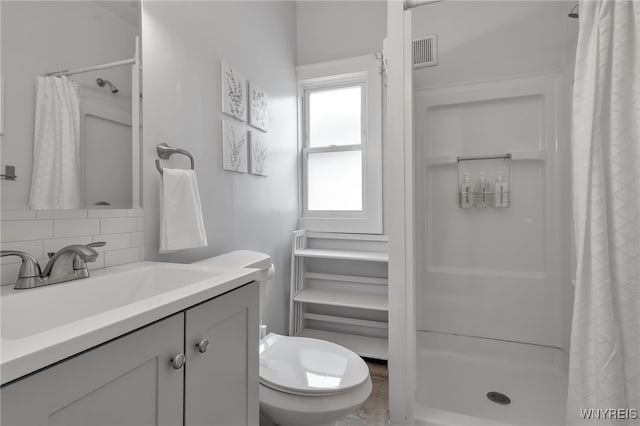 bathroom featuring toilet, tasteful backsplash, a shower stall, and visible vents