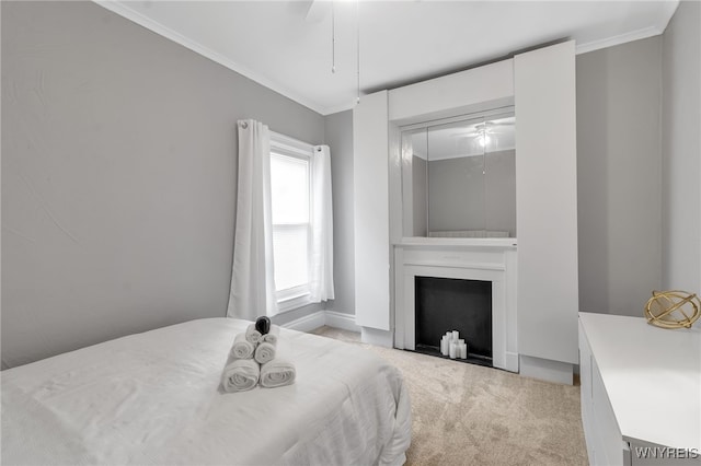 bedroom with ornamental molding, a fireplace, a ceiling fan, and light colored carpet