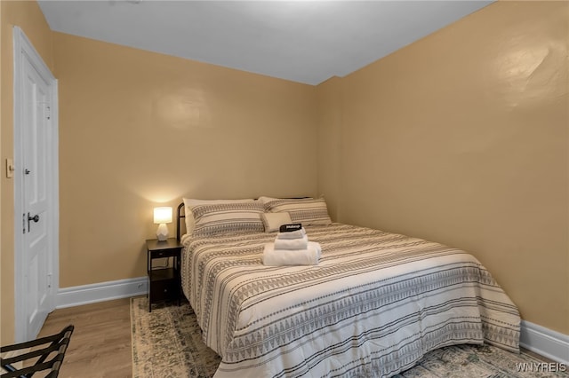 bedroom featuring baseboards and wood finished floors