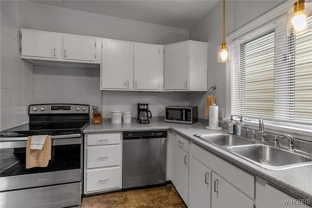 kitchen with appliances with stainless steel finishes, light countertops, white cabinetry, and a sink