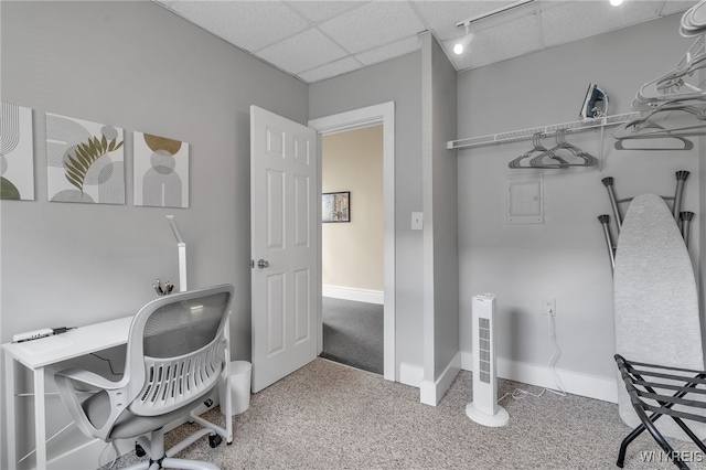 carpeted office featuring a drop ceiling and baseboards