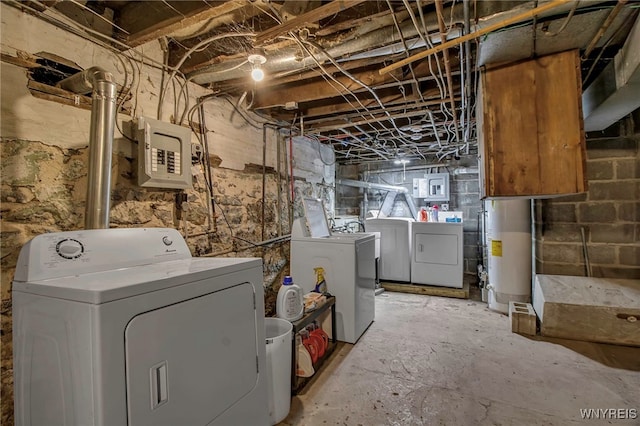 clothes washing area featuring laundry area, water heater, electric panel, and washing machine and clothes dryer