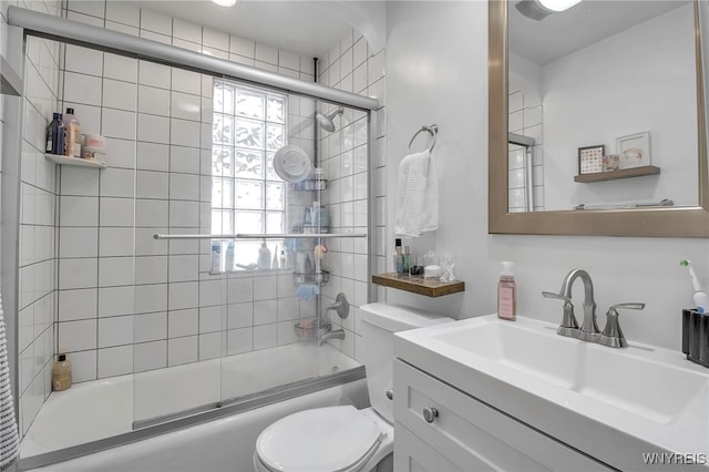 bathroom with toilet, enclosed tub / shower combo, and vanity