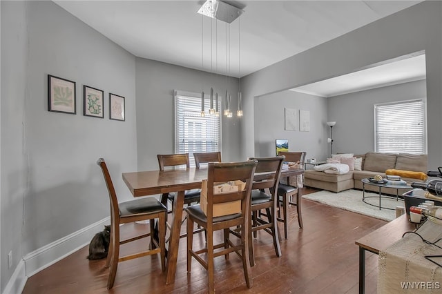 dining room with dark wood-style flooring and baseboards