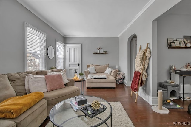 living room with arched walkways, crown molding, baseboards, and wood finished floors