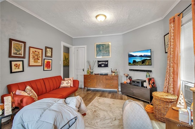 living area featuring ornamental molding, a healthy amount of sunlight, a textured ceiling, and wood finished floors