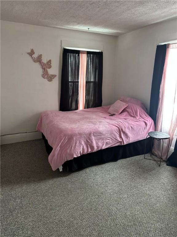 bedroom with a textured ceiling and carpet floors