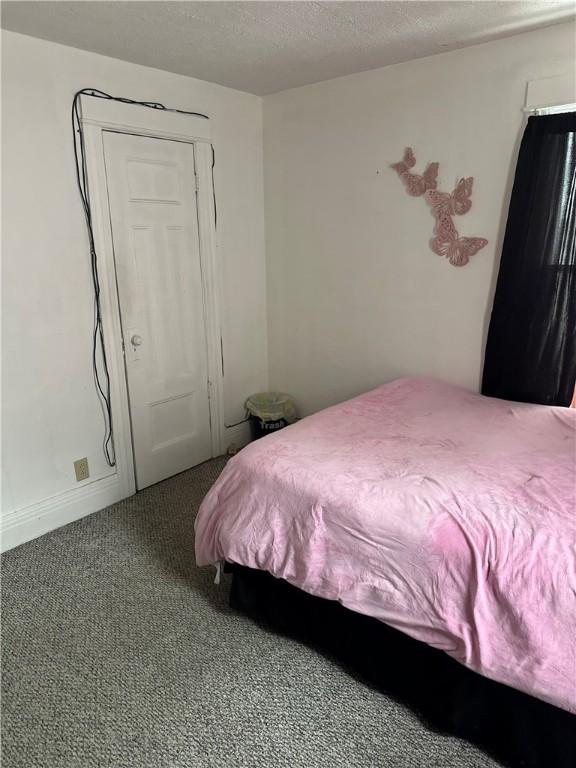 carpeted bedroom featuring a textured ceiling