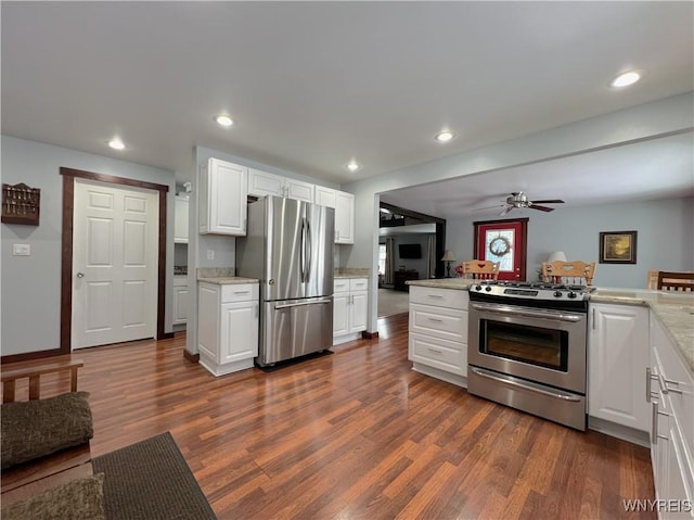 kitchen featuring stainless steel appliances, recessed lighting, dark wood-type flooring, open floor plan, and white cabinetry