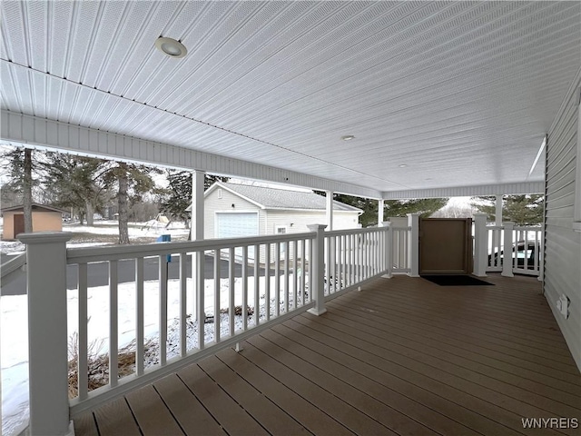 snow covered deck featuring an outbuilding