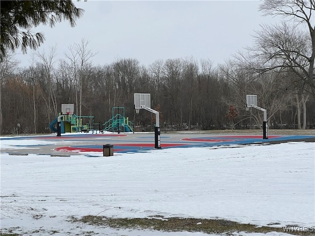 view of sport court with playground community, community basketball court, and a wooded view