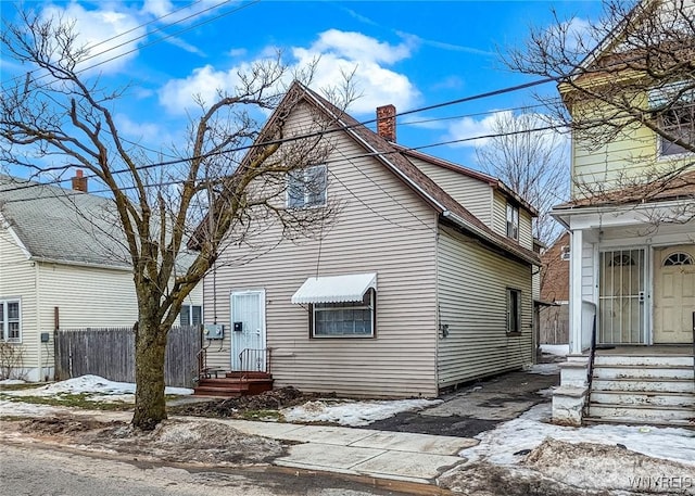 view of front of house with fence and a chimney