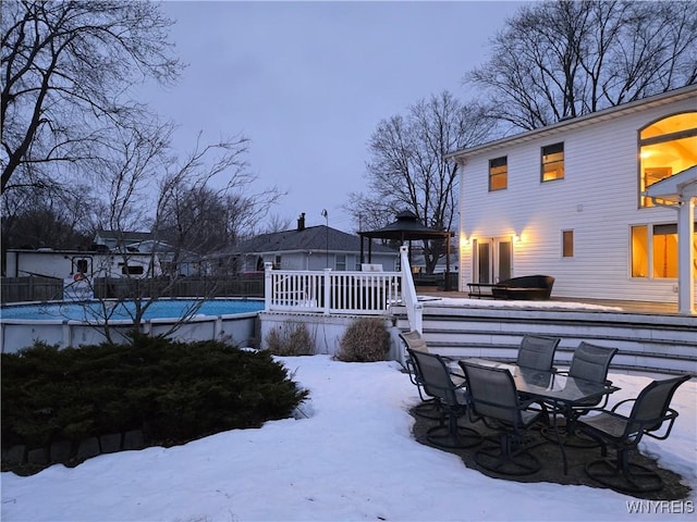 exterior space featuring a deck, a fenced in pool, and outdoor dining space