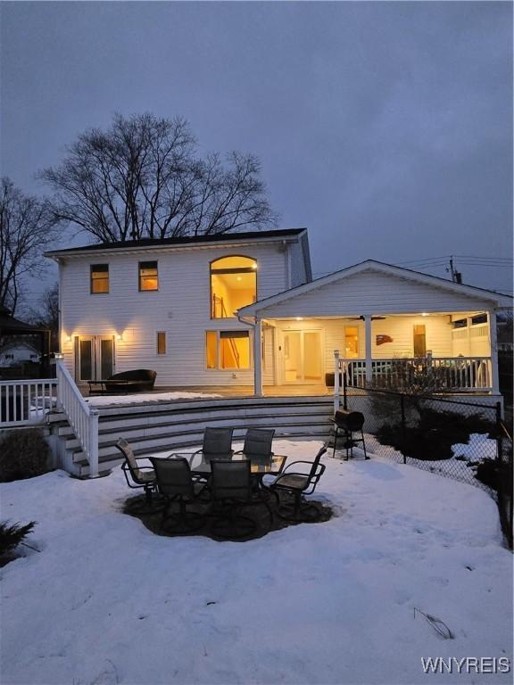 snow covered house featuring a wooden deck