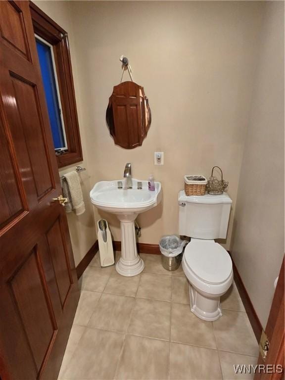 bathroom featuring toilet, baseboards, and tile patterned floors