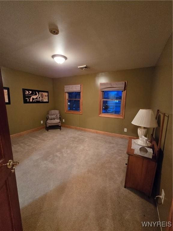 living area with carpet, visible vents, and baseboards