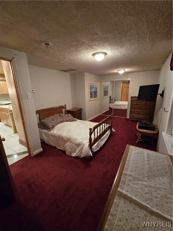 tiled bedroom with carpet floors and a textured ceiling