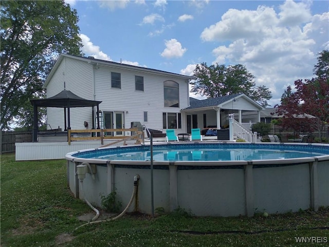 view of swimming pool featuring a fenced in pool, a yard, a gazebo, fence, and a deck