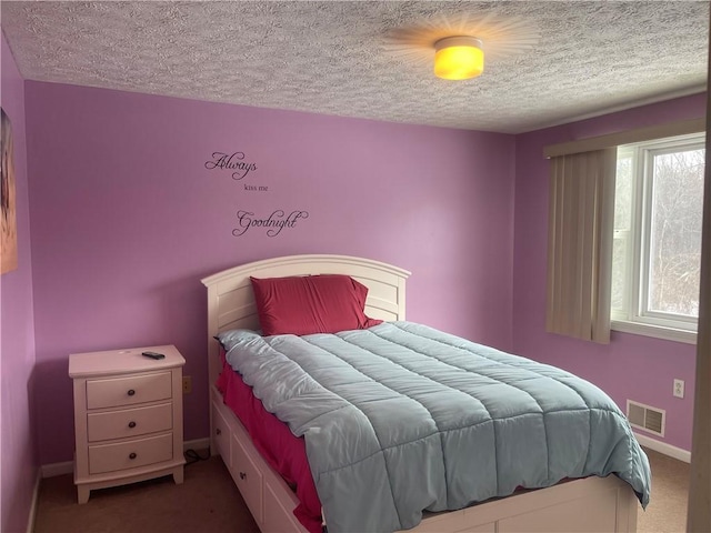 bedroom featuring carpet floors, baseboards, visible vents, and a textured ceiling