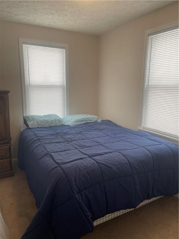 bedroom featuring carpet flooring and a textured ceiling