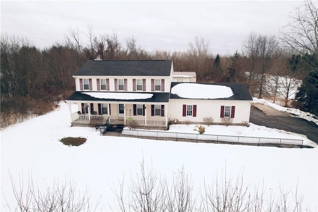 snow covered rear of property featuring a porch