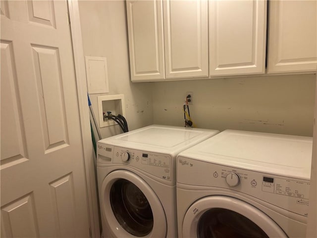 laundry area featuring washing machine and clothes dryer and cabinet space