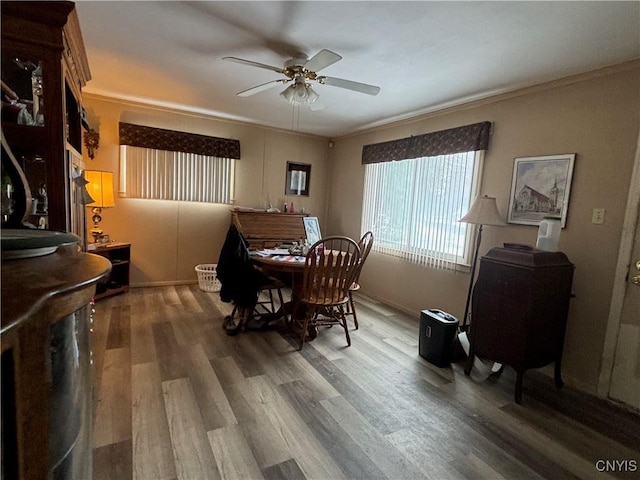 dining area with ornamental molding, a ceiling fan, and wood finished floors