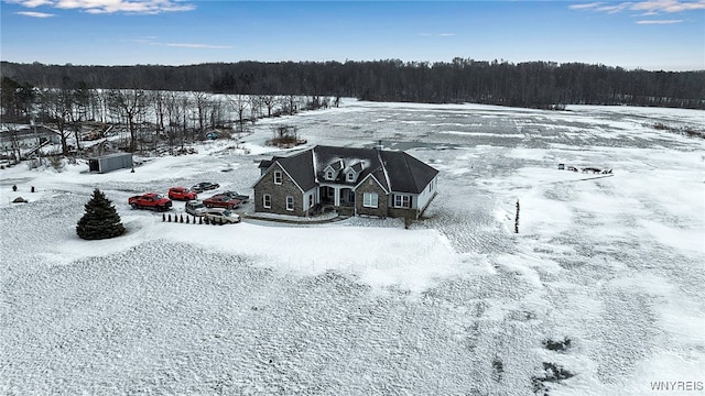 snowy aerial view featuring a view of trees